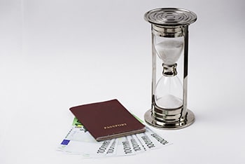 Red passport with euro banknotes and hourglass on a white background. Grindelwald - Suiza